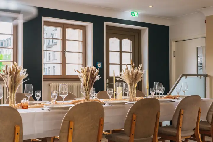 Elegant eingedeckte Tafel vor anthrazitfarbener Wand im Umspannwerk Halle