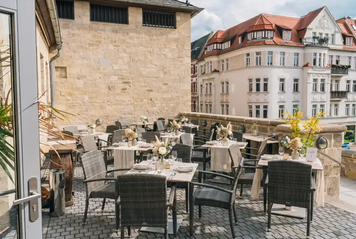 Eingedeckte Tische auf der Terrasse des Umspannwerks mit Blick auf die Altstadt von Halle (Saale) – Visualisierung